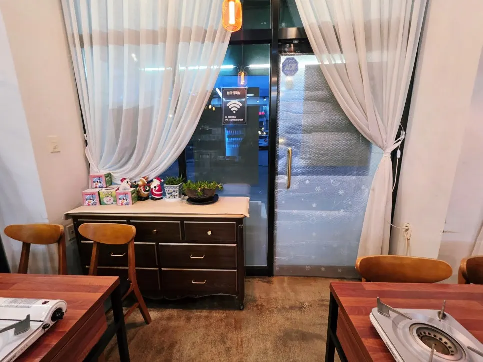 Interior of Eomma-ui Ttuksim with wood-tone tables and white curtains