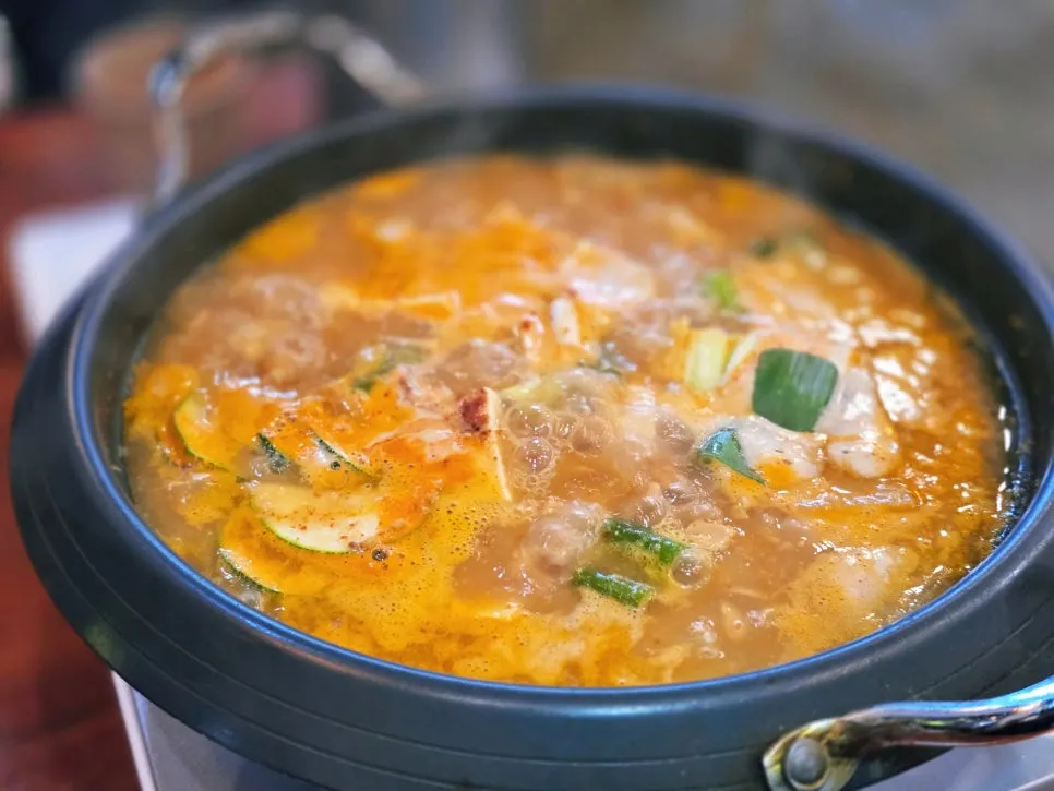 A pot of cheonggukjang loaded with tofu and vegetables