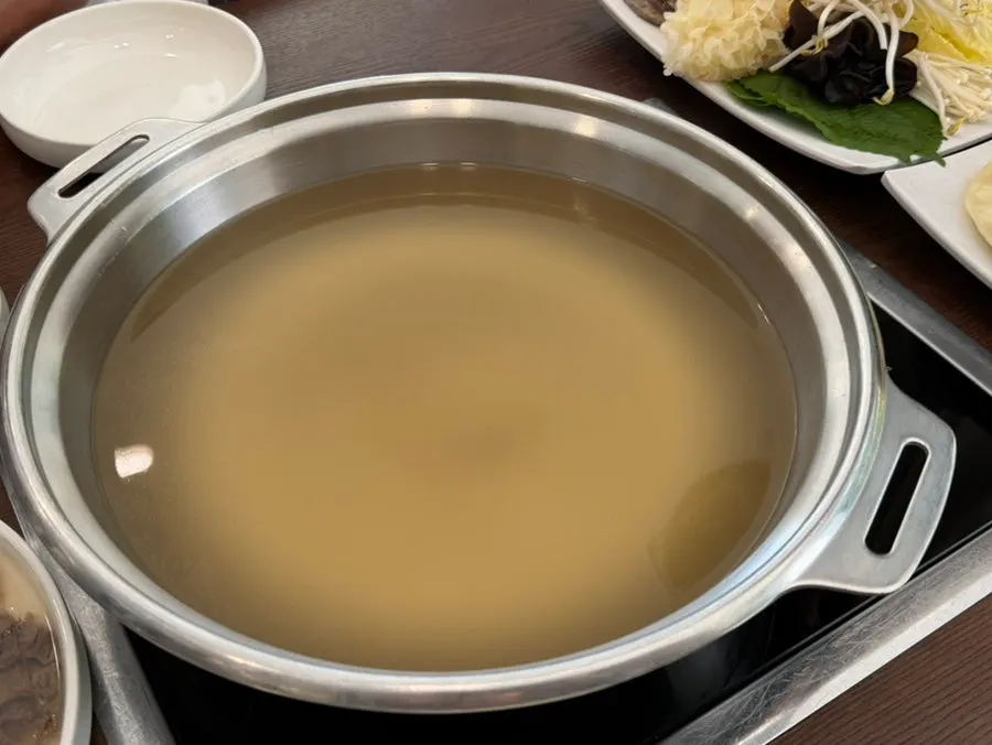 평양만두 8개와 칼국수 사리, 채소가 담긴 만두전골