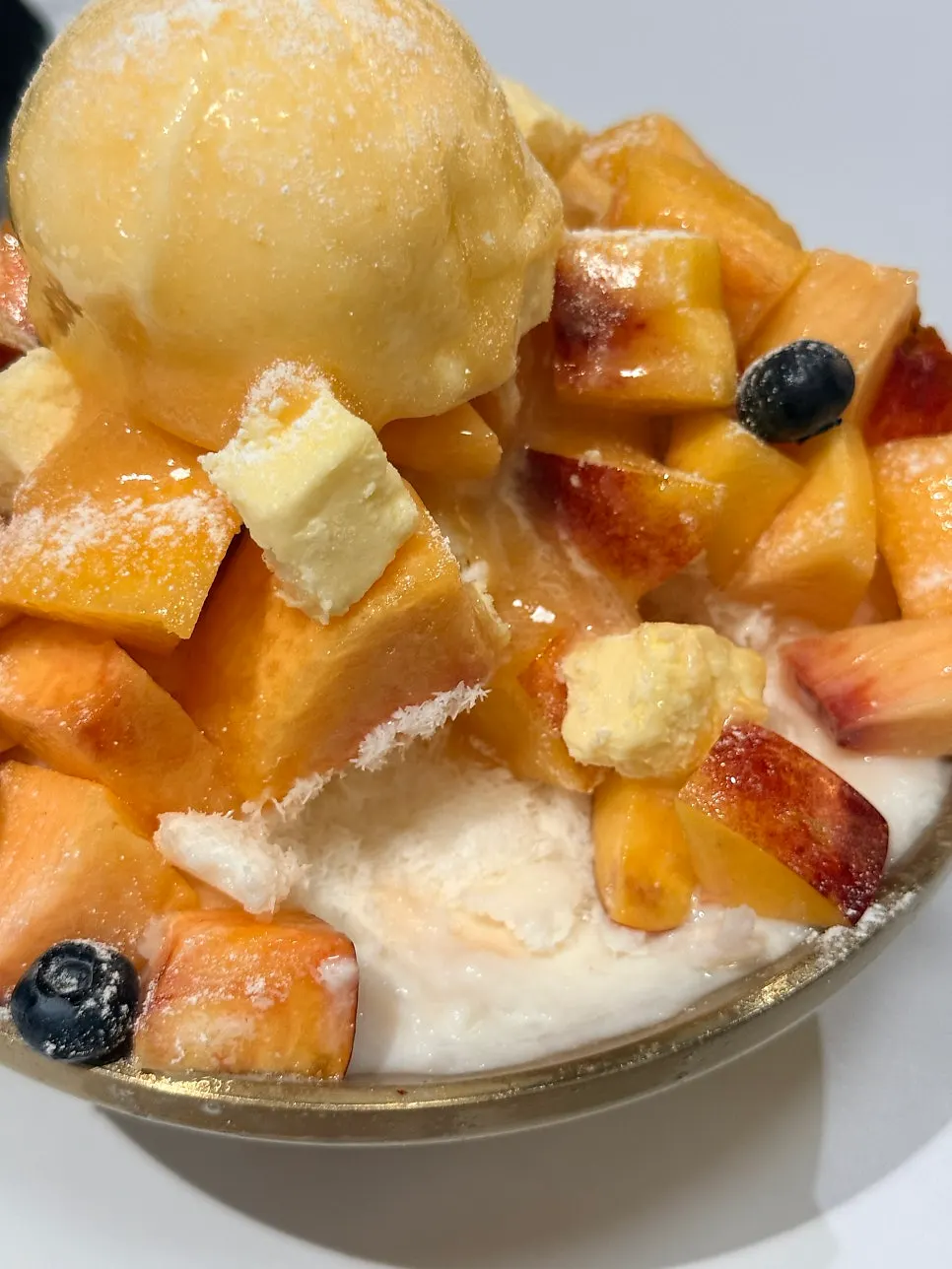 Close-up of peach snow flower bingsu dusted with sugar powder