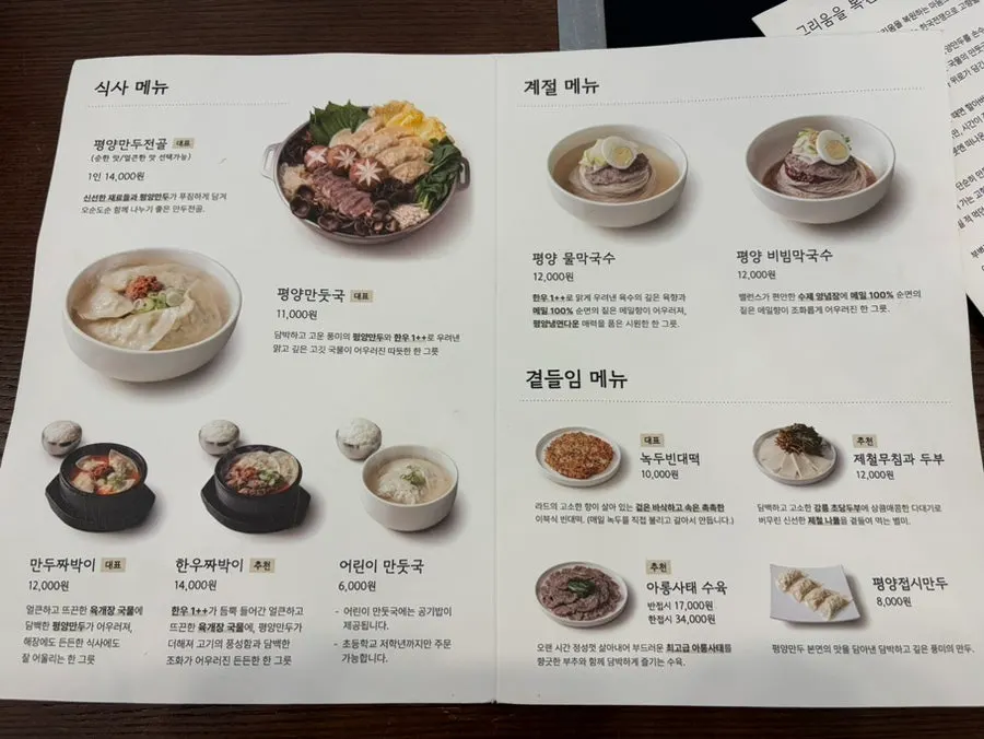 Menu board listing Pyeongyang mandu hot pot and makguksu