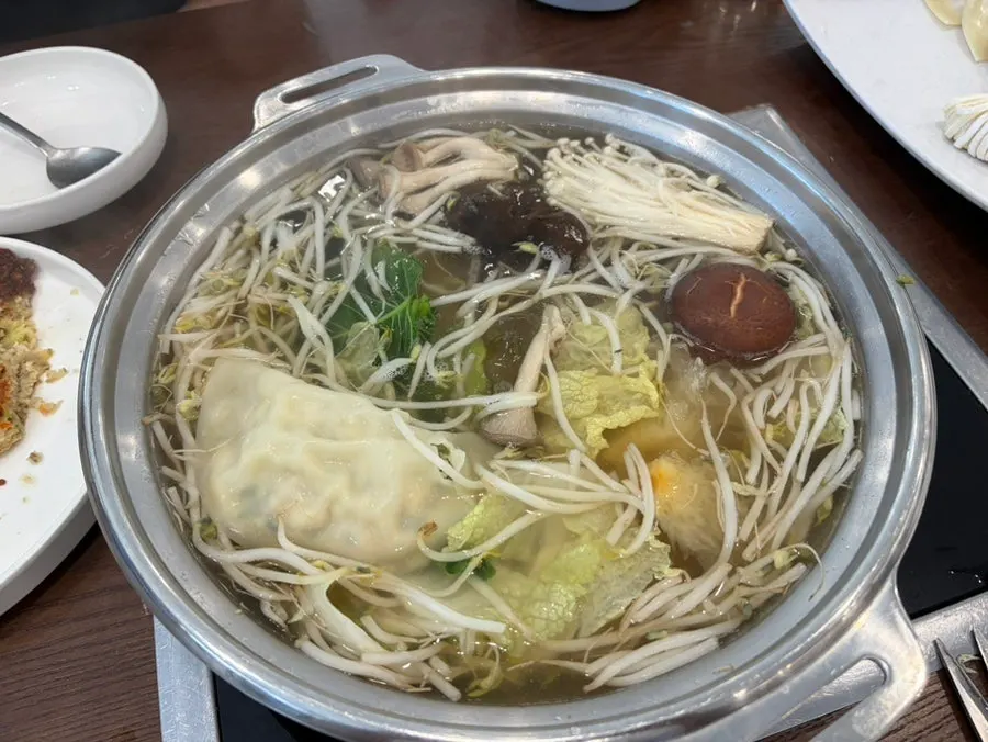 Fully cooked dumplings inside the Pyeongyang mandu hot pot