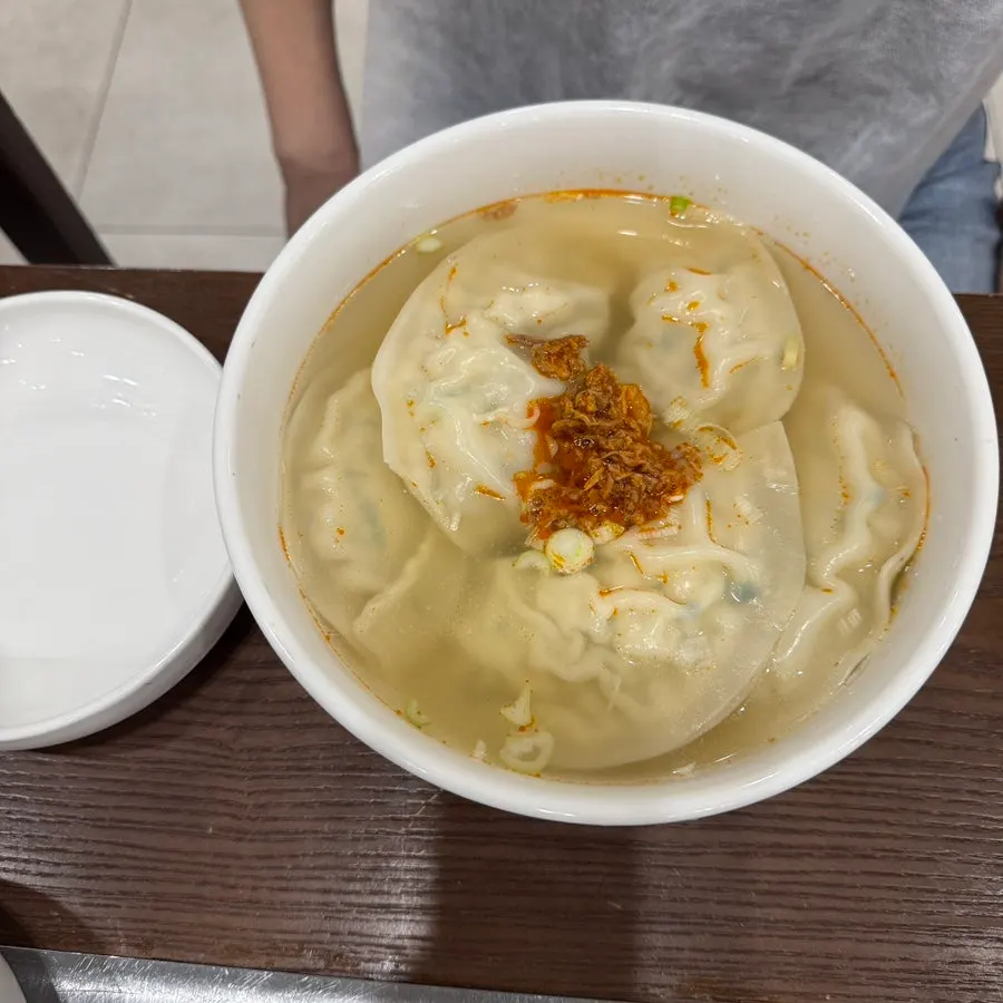A bowl of Pyeongyang mandu soup with large dumplings