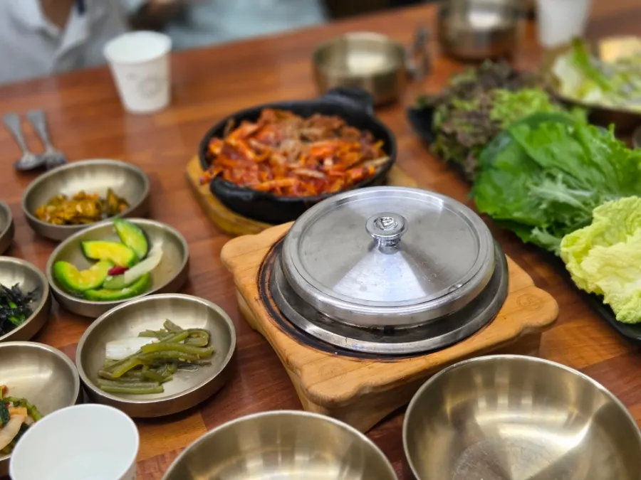 쌈 채소에 밥과 제육을 올린 쌈