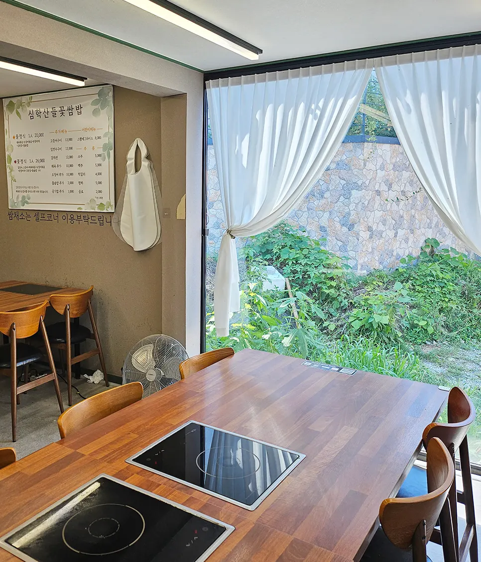 Dining space with trees landscaped outside the window