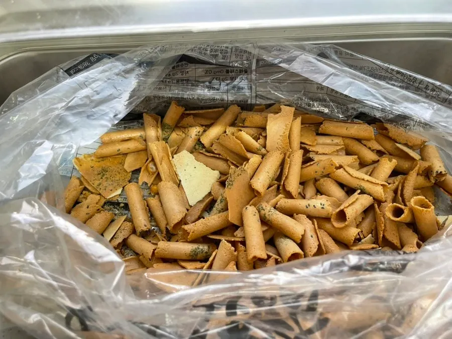 Basic banchan and rice crackers laid out at the self-serve bar