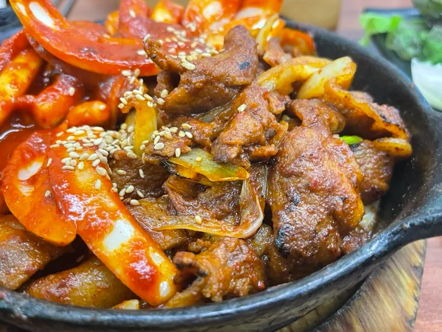 Bright red squid stir-fry served on a hot stone plate