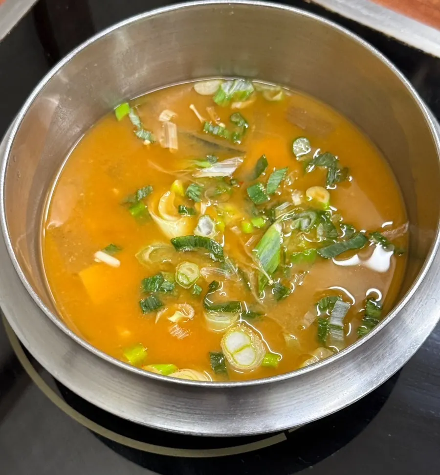 House-made doenjang stew heating on the burner