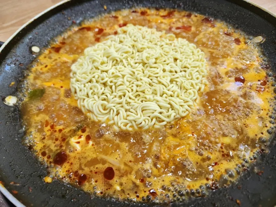 Budae jjigae filled with ham, sausage, rice cake, and glass noodles