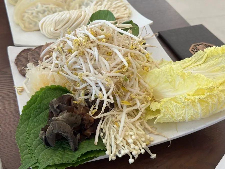 A hot-pot spread with mandu and vegetables