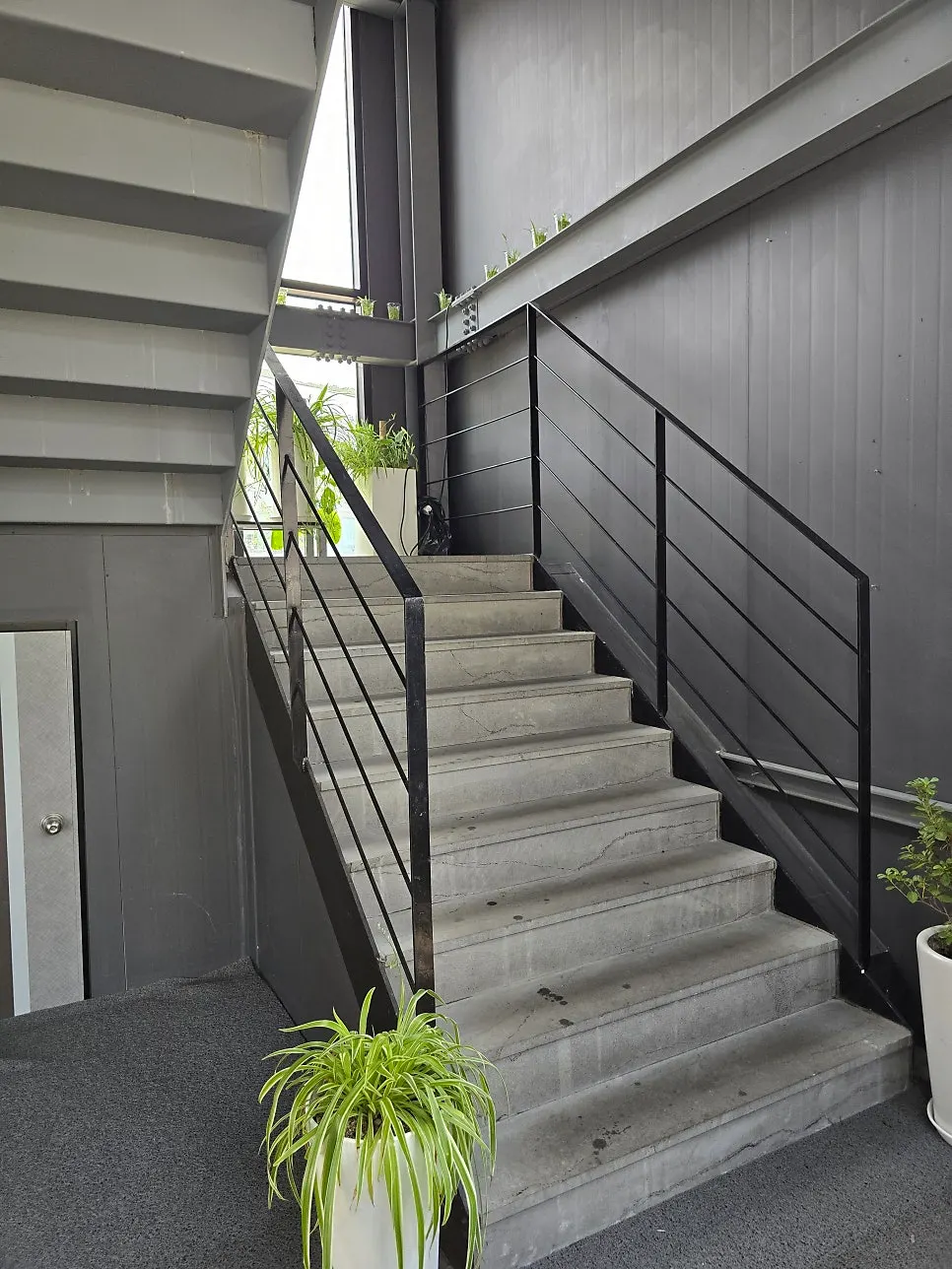 Exposed concrete staircase leading up to the 2nd floor