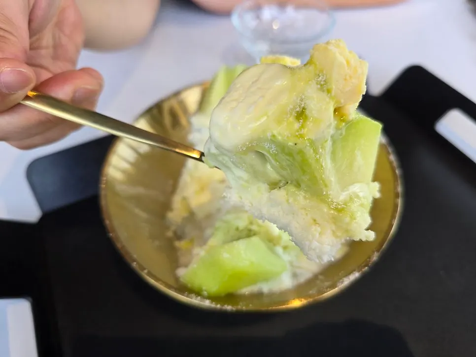 A thick fresh melon piece lifted on a spoon