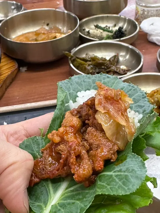 A ssambap wrap piled with banchan and stew