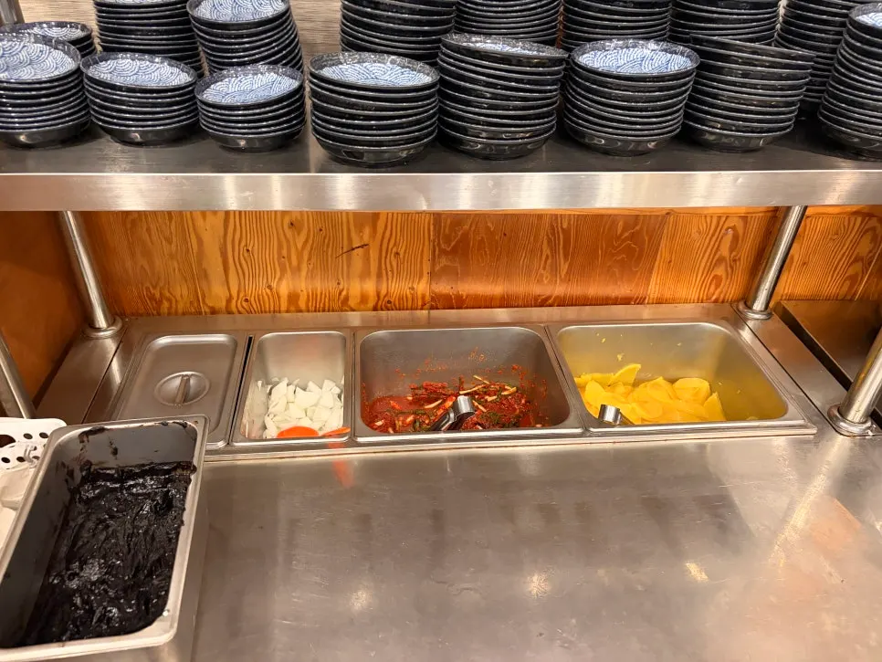 Self-serve bar at Dolpanseok Jjamppong stocked with basic side dishes