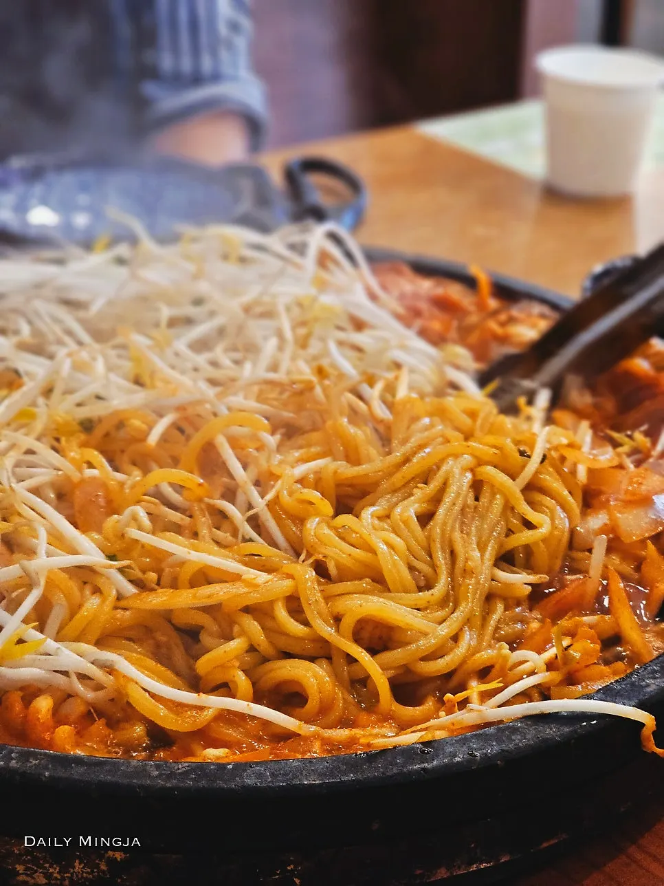 Jjamppong noodles scooped up with bean sprouts