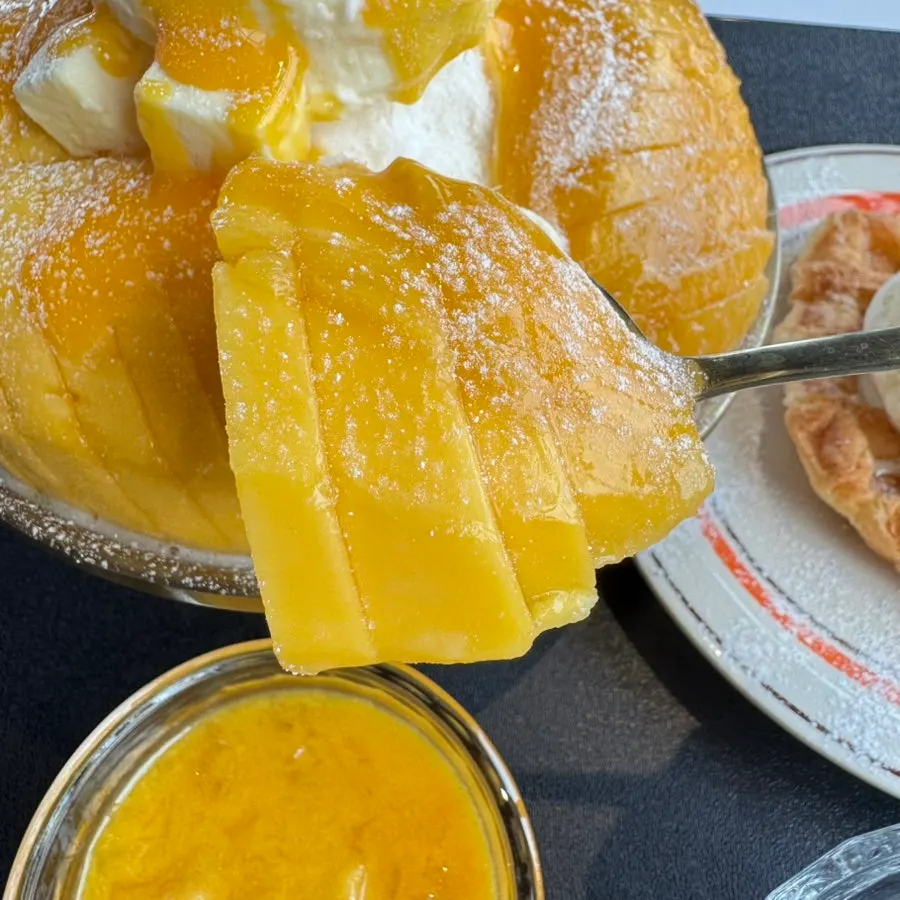 Mango bingsu topped with cream cheese and vanilla ice cream
