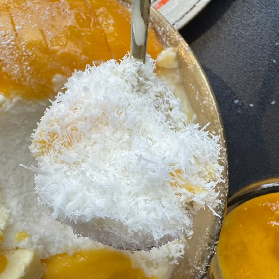 A bite of fresh mango bingsu with the fruit flavor coming through