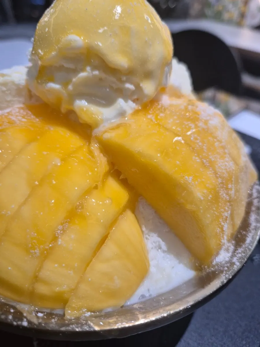 Side view of the bingsu topped with about two mangoes' worth