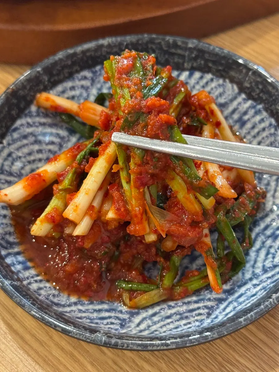 Green onion kimchi served alongside the dish