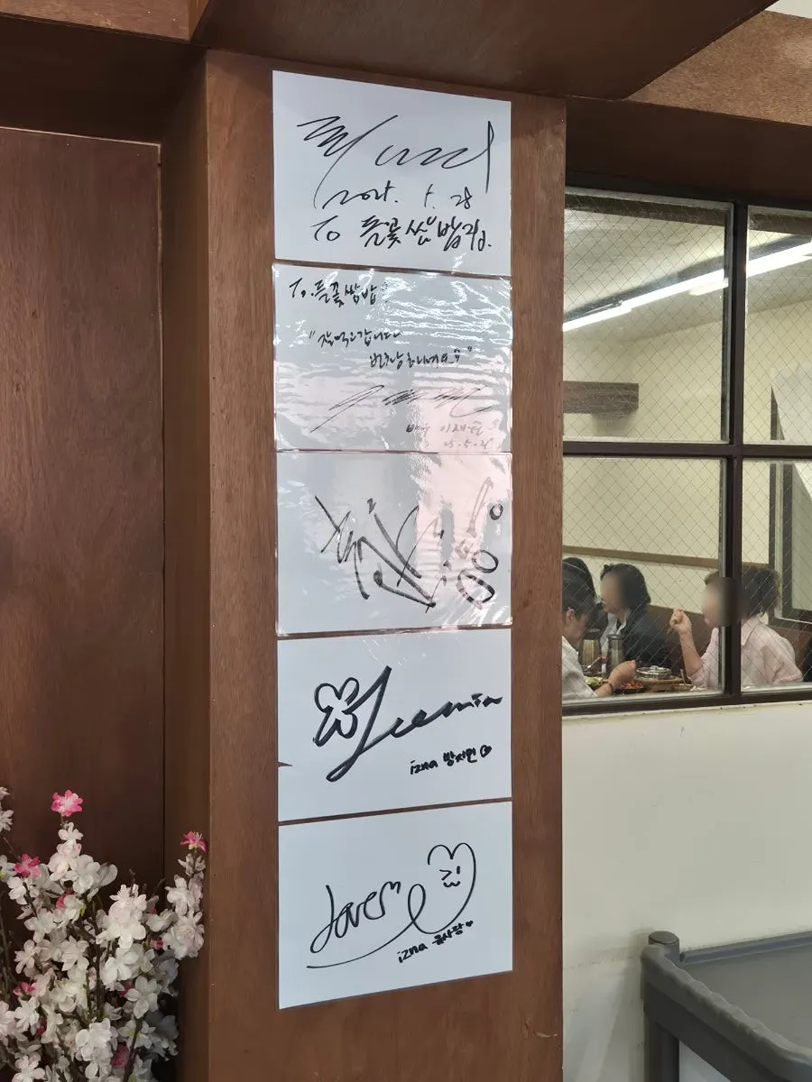 Interior tables and celebrity autographs at Deulkkot Ssambap