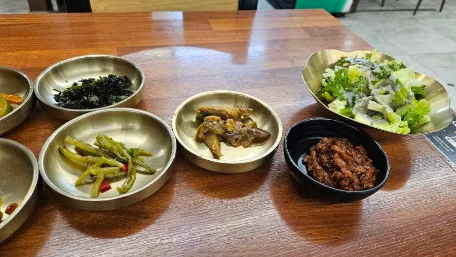 Table set with deuljeongsik banchan and wrap greens