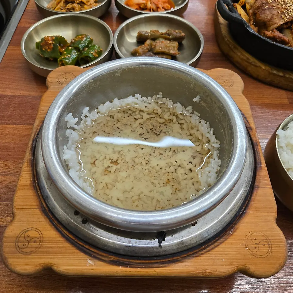 Pouring hot water into the stone pot after scooping out the rice