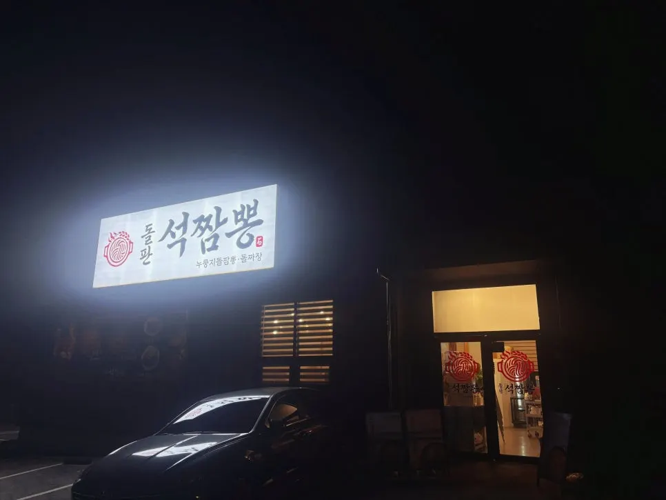 Sign for Dolpanseok Jjamppong Paju Simhaksan Branch lit up in the evening