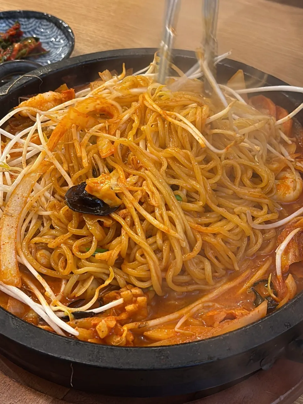Fideos y brotes de soja mezclados sobre la plancha de piedra