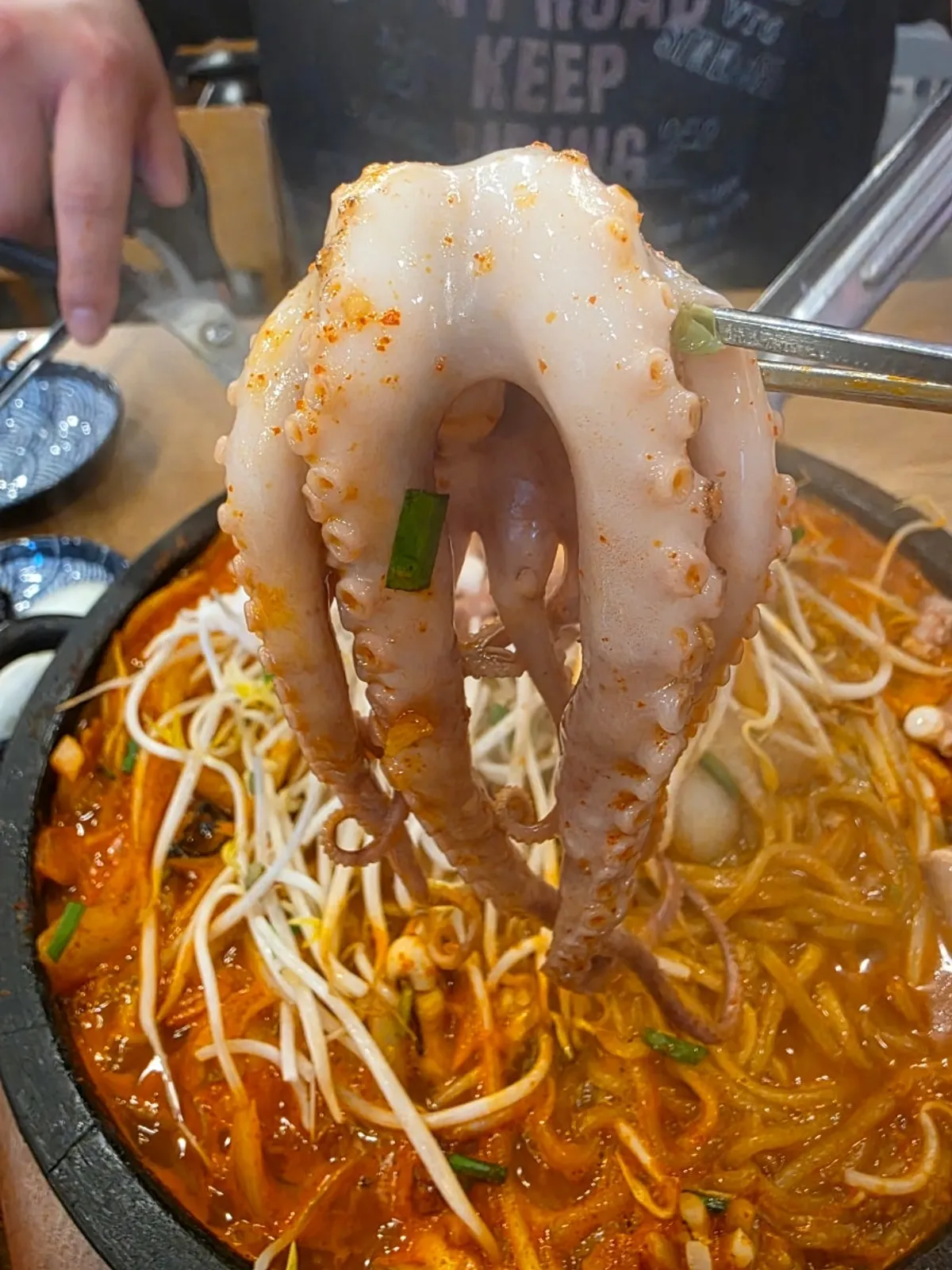 Signature shot of stone jjamppong bubbling on the hot plate