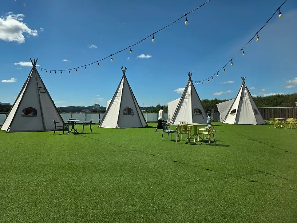 Outdoor terrace with artificial grass and an Indian-style tent