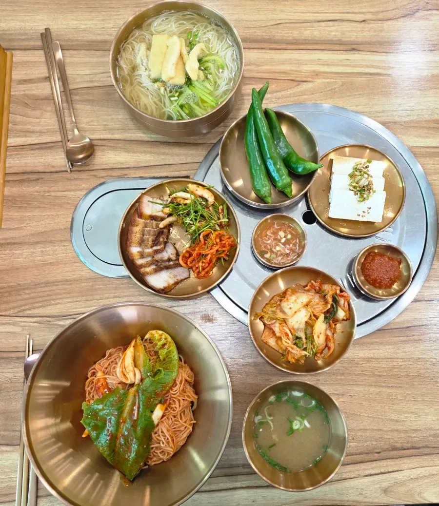 Table spread of janchi guksu, bibim guksu, and one serving of suyuk
