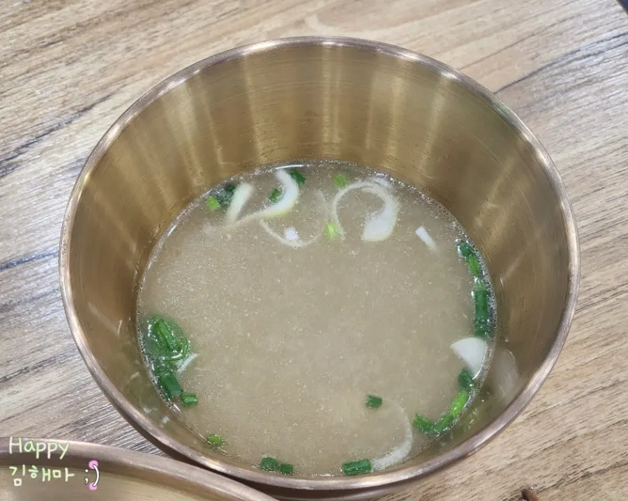Warm doenjang broth served alongside the bibim guksu