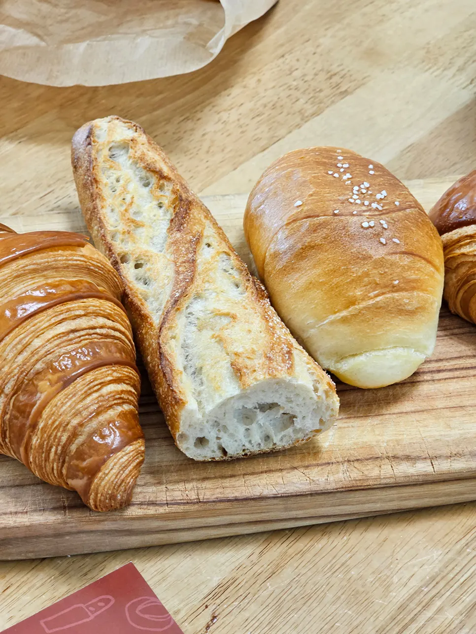 Croissant with well-defined layers next to a generous baguette