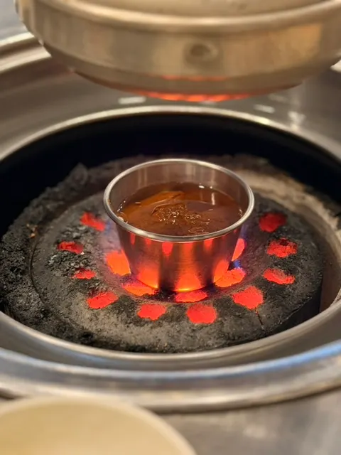 Charcoal fire and myeolchi-jeot placed at the table