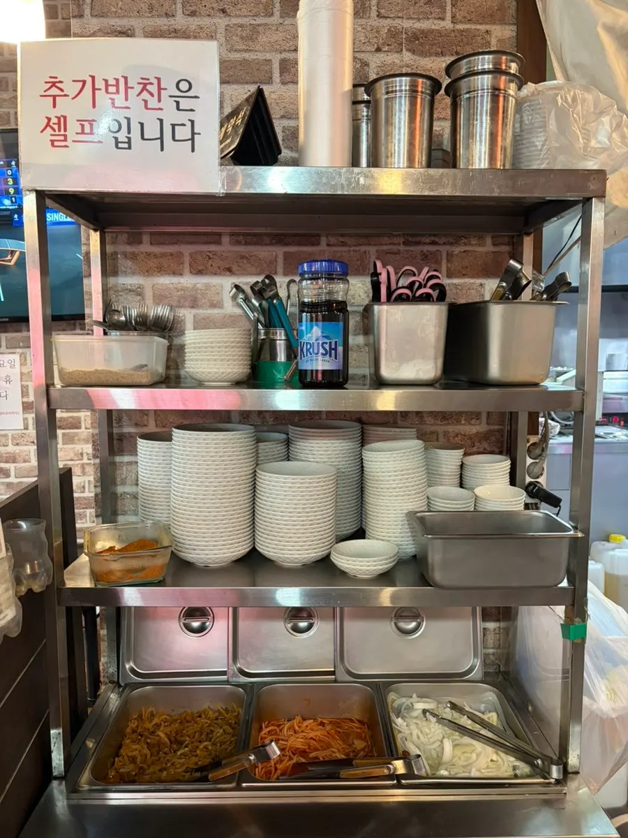 Self-serve banchan corner with jjasai, onion, and spicy radish salad