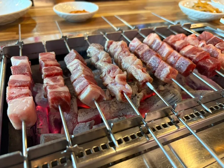 Lamb skewers turning over charcoal