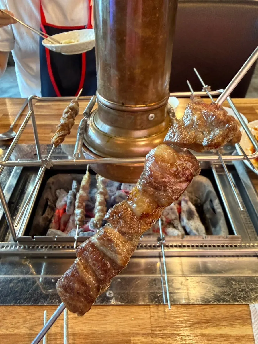 Lamb skewer about to be dipped in seasoning