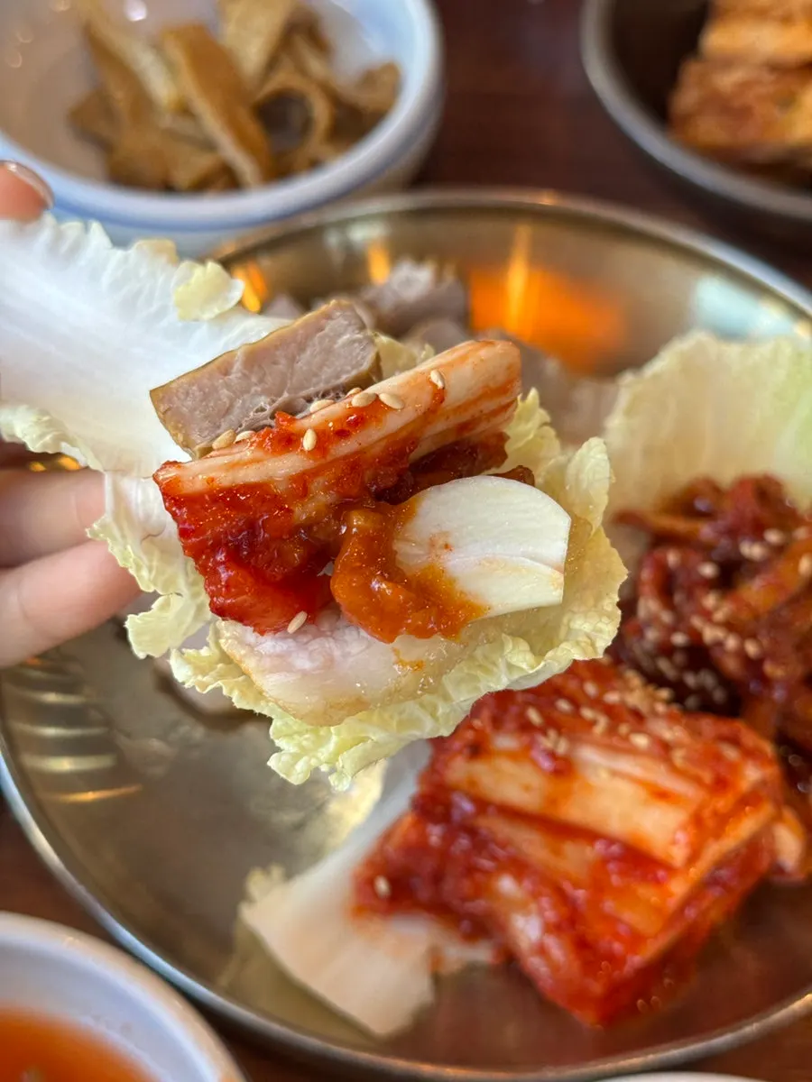 배추쌈에 올린 보쌈 고기와 김치