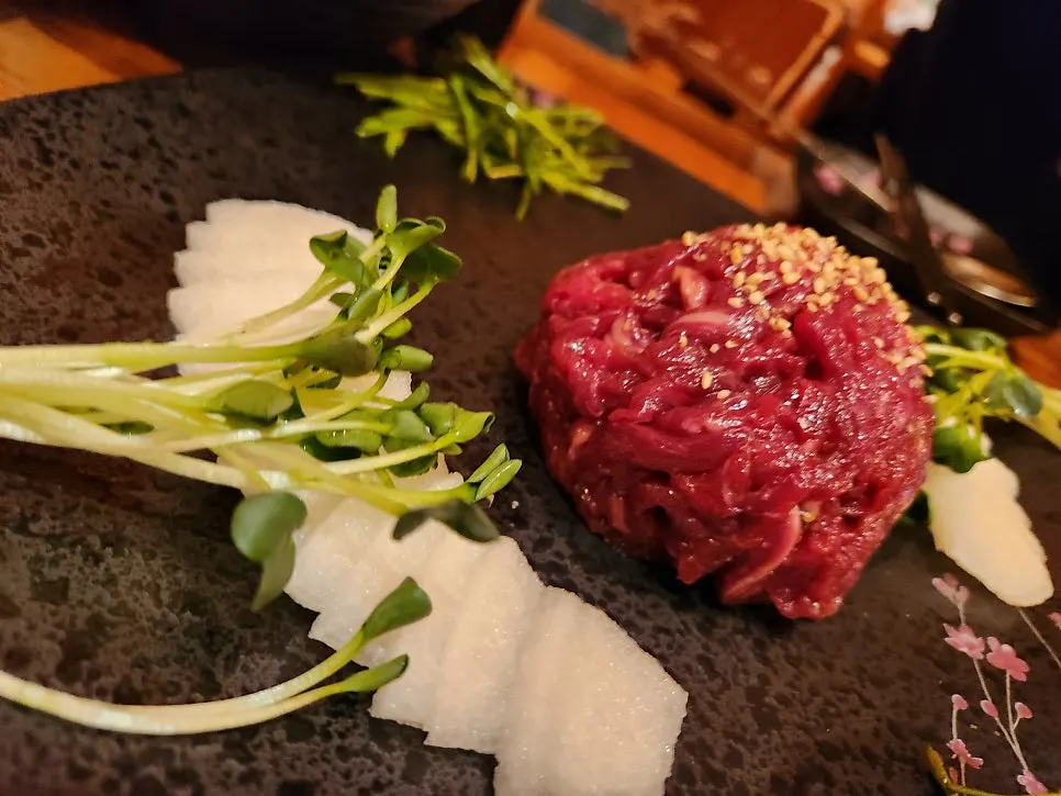 육회 한 점을 집어 올린 모습