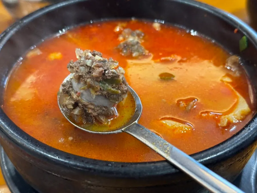 수육 한 점을 집어 든 모습