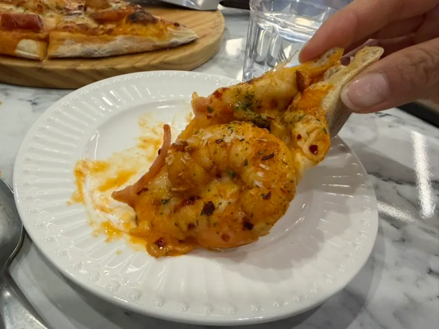 Shrimp spilling off a pizza slice