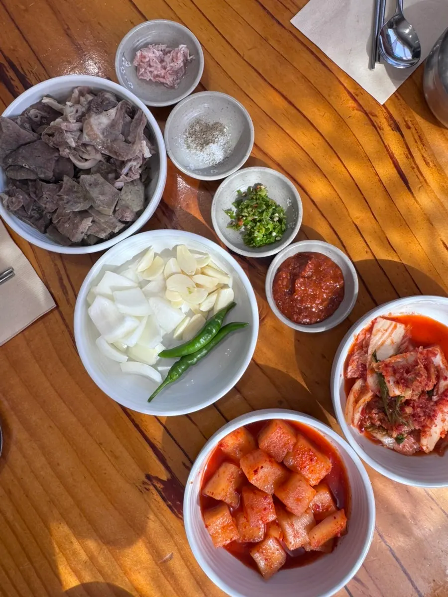 새우젓, 쌈장, 양파와 마늘이 놓인 밑반찬 접시