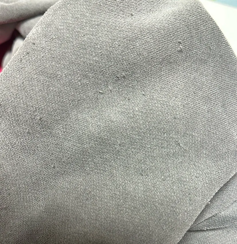 Moving the lint remover back and forth over clothing to remove lint
