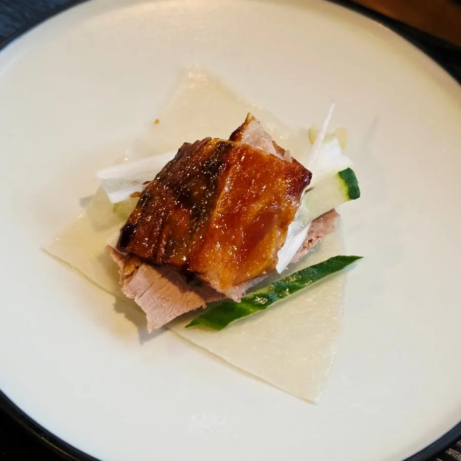 Peking duck meat and vegetables placed on a thin pancake