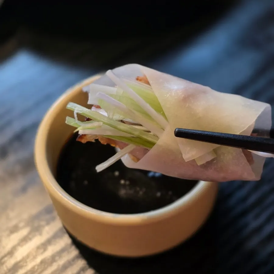 Wrapping the pancake with Peking duck sauce added