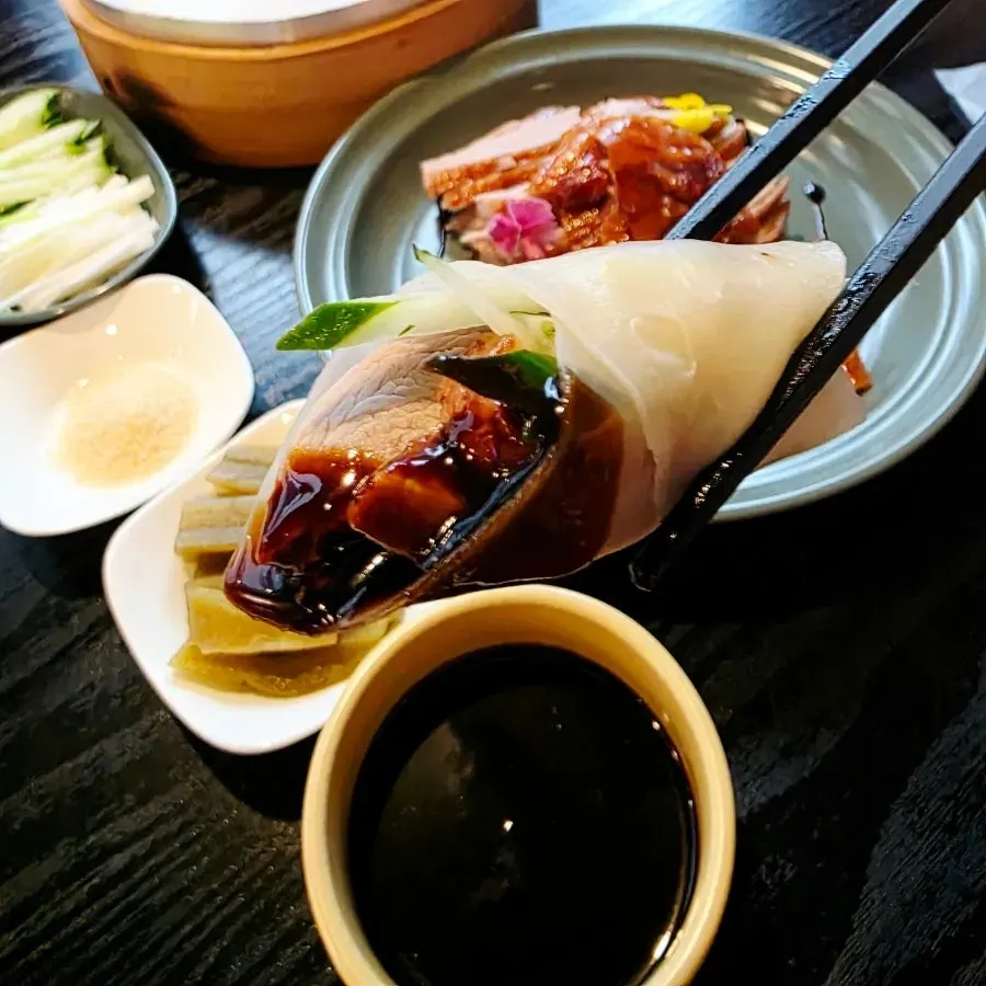 A finished bite of Peking duck wrapped in a pancake