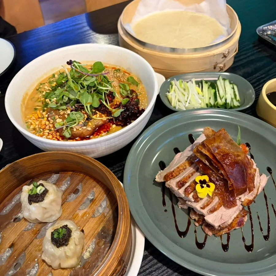 Table with Peking duck and dan dan noodles