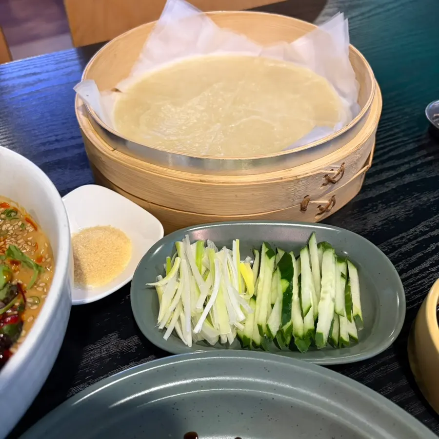 Table with pancakes, scallion, and cucumber strips for Peking duck