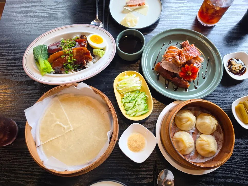 A spread of half Peking duck, xiaolongbao, and dongpo pork rice bowl