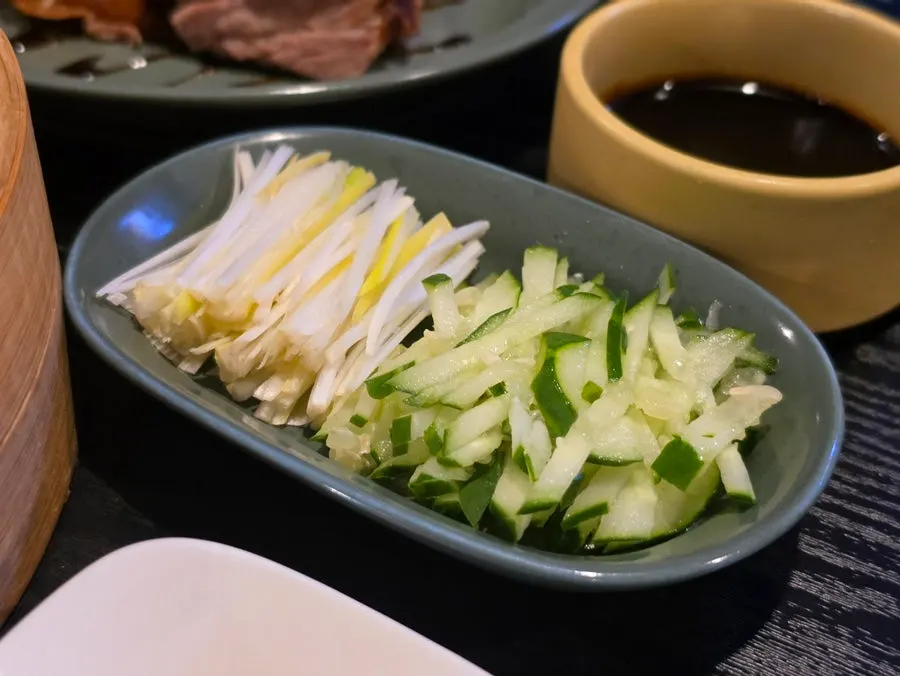 裝著小黃瓜、青蔥與醬汁的盤子